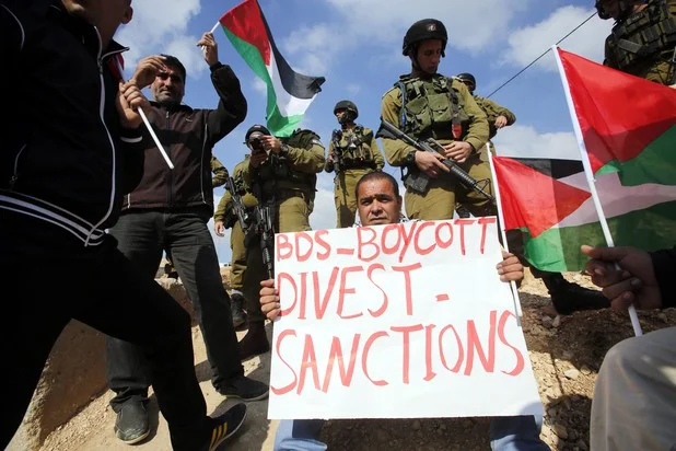 Israeli occupation forces surround Palestinian protestors near the village of Jabaa in the southern West Bank on 14 March. ( Abed Al Hashlamoun / EPA )